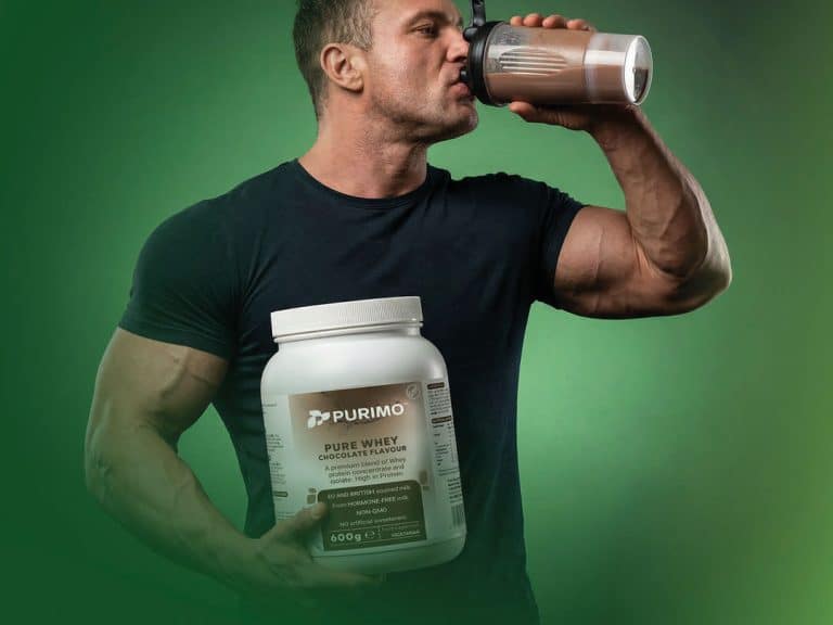 A muscular man drinking Purimo Pure Whey protein powder, one of the healthiest and best protein powders.